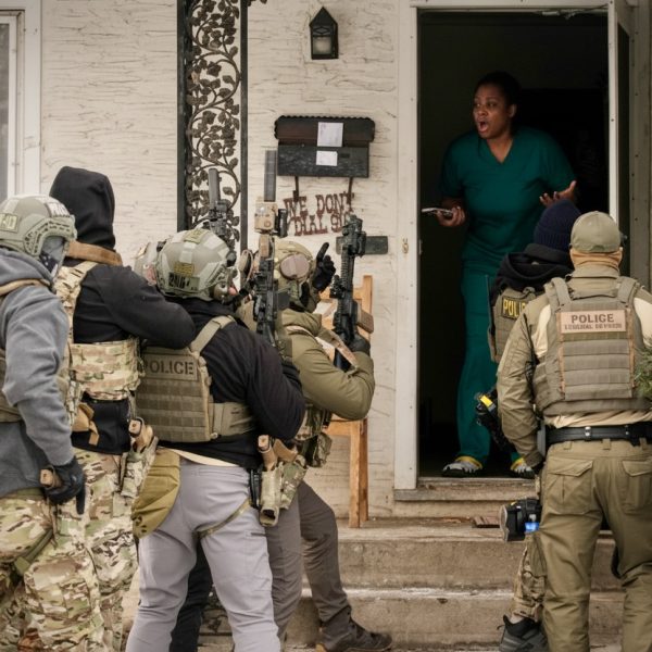 Armed police tactical team entering a residence aggressively