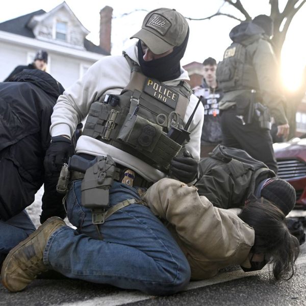 Police officers arresting suspect on the ground